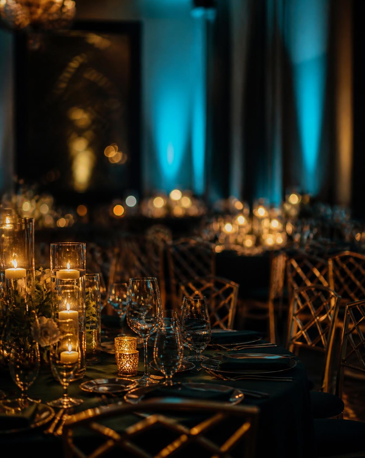 An awards evening room lit with candlelight and deep teal light