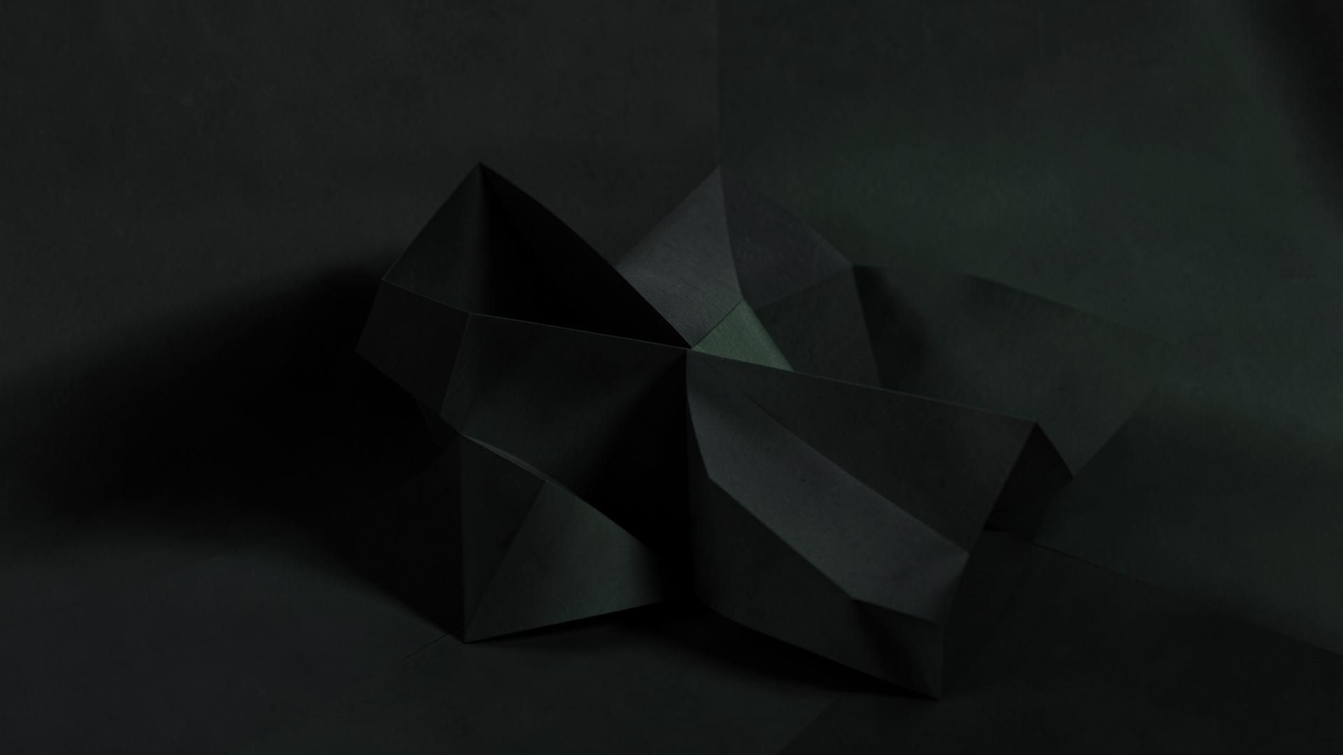 Sculptural folded forms in low green light